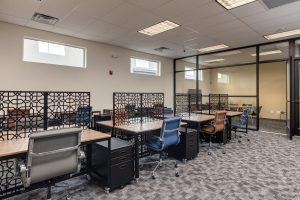 A large open room with several desks separated by intricate iron dividers.