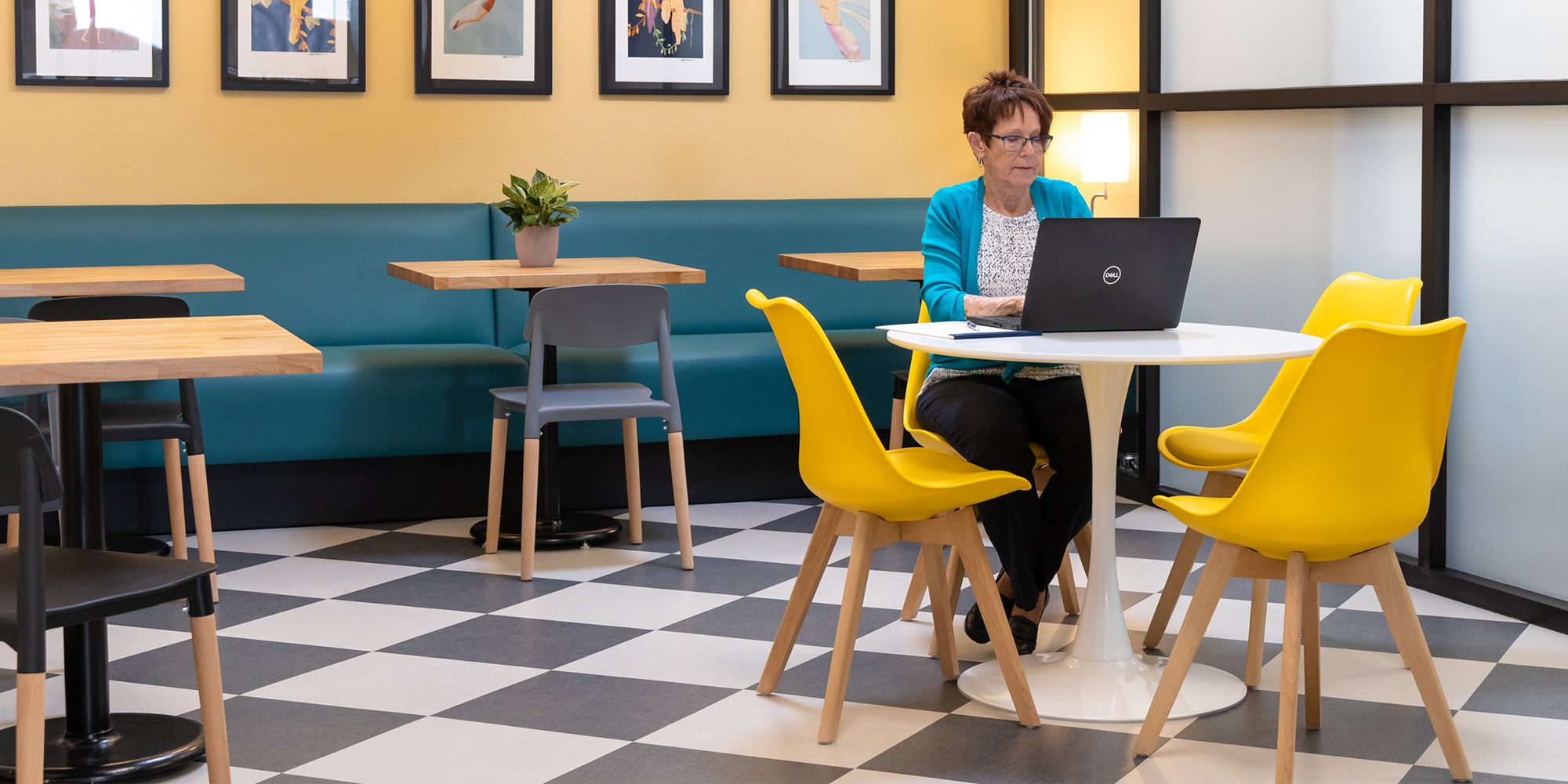A woman works on her laptop in our kitchenette area in our coworking space.