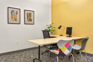 office with L-shaped desk and orange and white walls