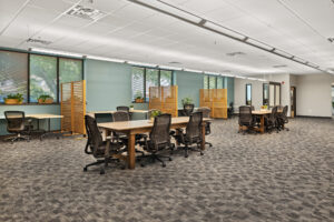 room with tables and a teal wall, orange separators between individual tables