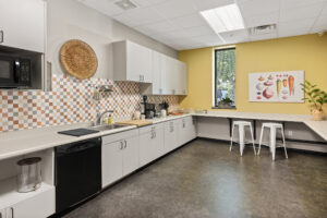 kitchen with white and orange walls and white cabinets